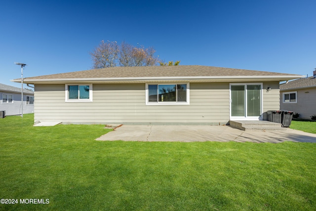 rear view of property with a yard and a patio area