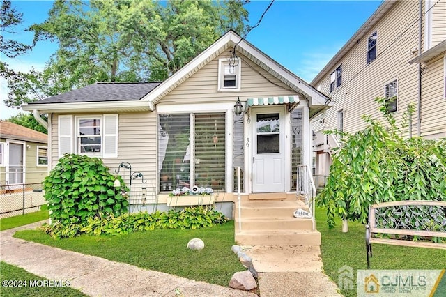 bungalow-style house featuring a front lawn