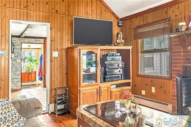 living room with lofted ceiling, wooden walls, hardwood / wood-style floors, and a baseboard heating unit