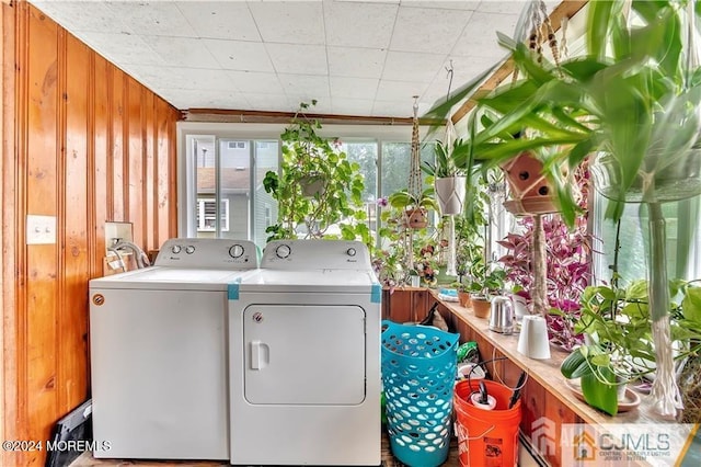 laundry area featuring independent washer and dryer and wood walls