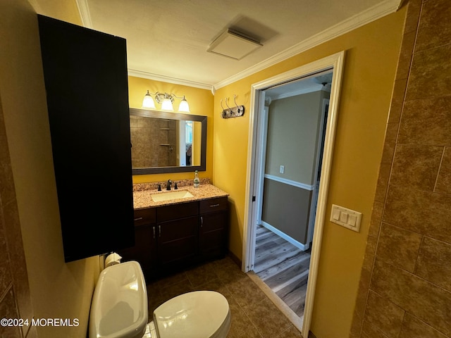 bathroom with vanity, ornamental molding, hardwood / wood-style flooring, and toilet