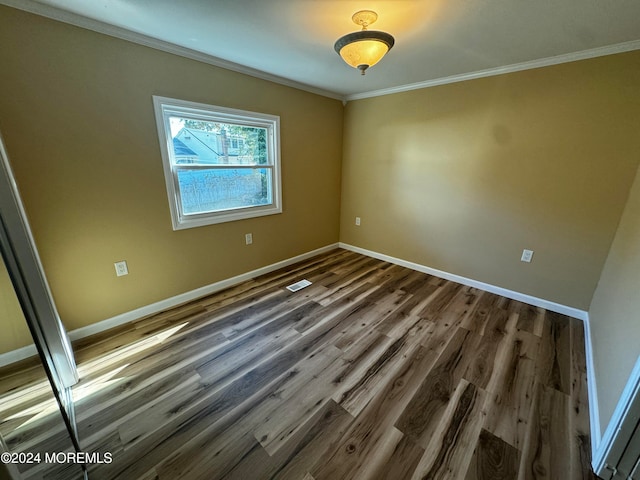 unfurnished room with crown molding and dark hardwood / wood-style flooring