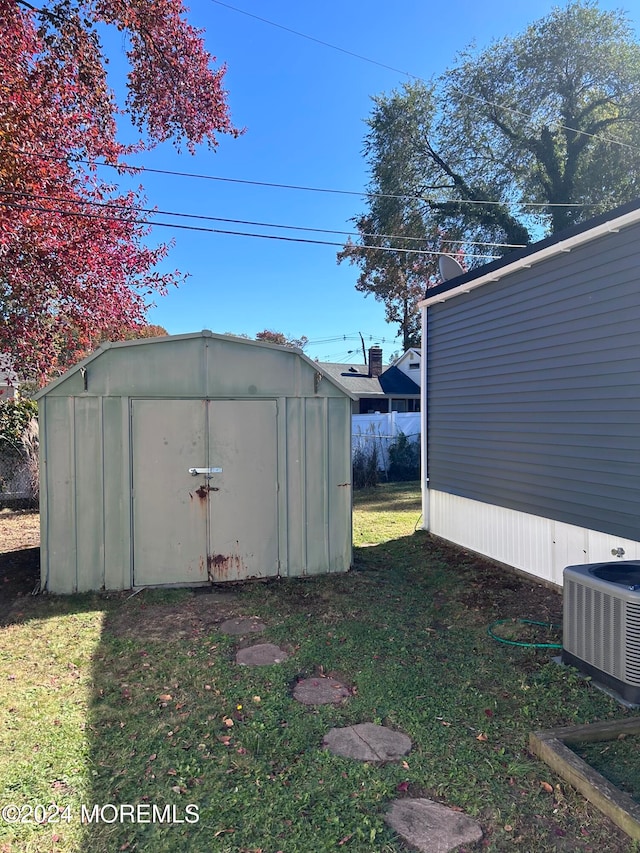 view of outbuilding featuring cooling unit and a lawn