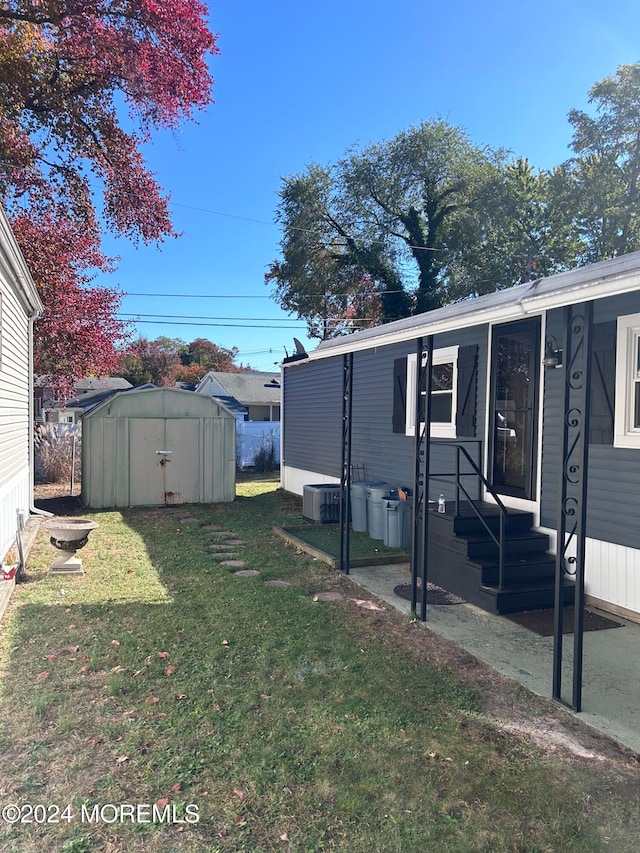 view of yard featuring cooling unit and a storage shed