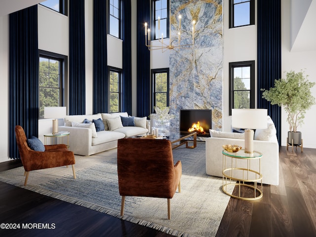 living room featuring a fireplace, a notable chandelier, wood-type flooring, and a high ceiling