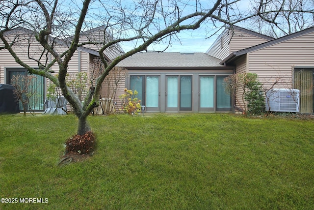 rear view of house with a lawn and central air condition unit