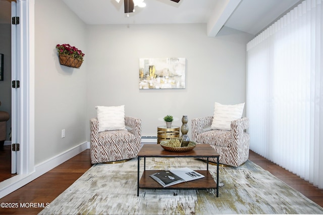 living area featuring hardwood / wood-style flooring, a baseboard radiator, vaulted ceiling with beams, and ceiling fan