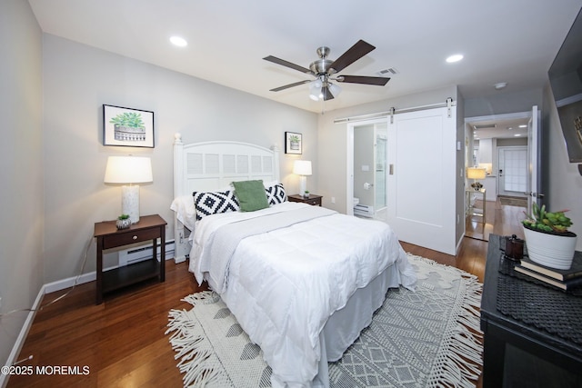 bedroom with dark hardwood / wood-style floors, a barn door, and ceiling fan