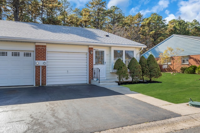 view of front of property with a front yard and a garage