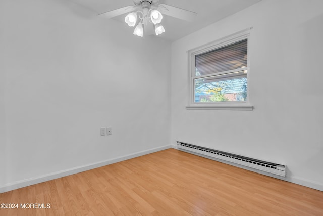 empty room featuring baseboard heating, light wood-type flooring, and ceiling fan