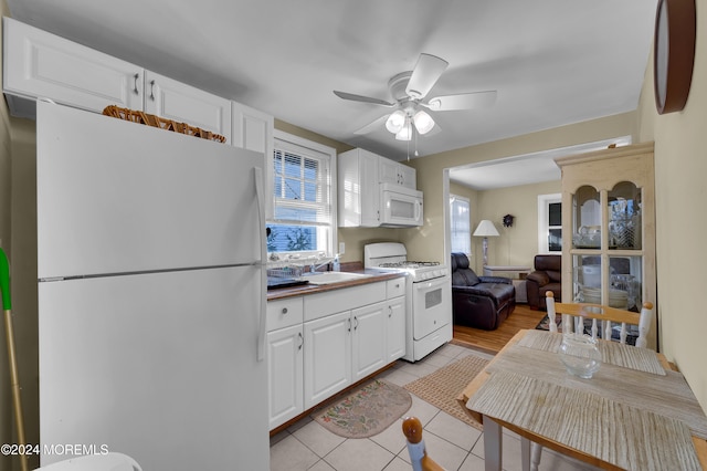 kitchen featuring light tile patterned floors, white cabinetry, white appliances, and ceiling fan