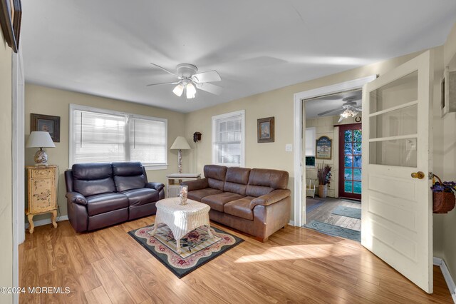 living room with light wood-type flooring and ceiling fan