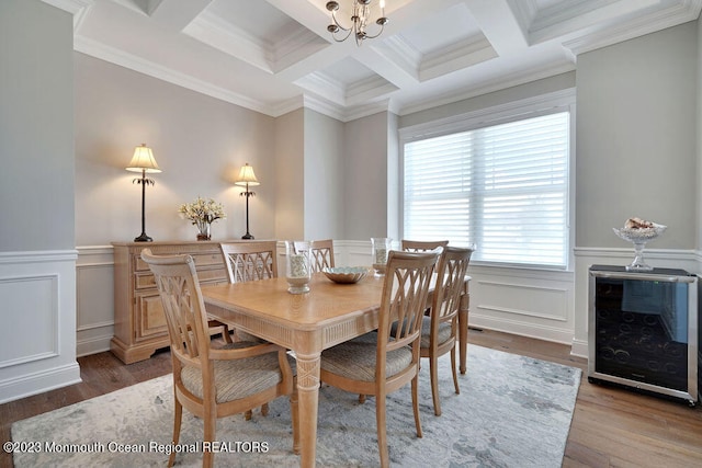 dining area with crown molding, hardwood / wood-style flooring, a chandelier, and beamed ceiling