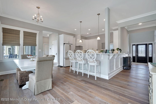 dining area featuring crown molding, light hardwood / wood-style floors, and a notable chandelier