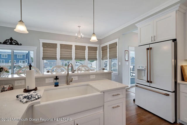 kitchen with high end fridge, decorative light fixtures, and white cabinets