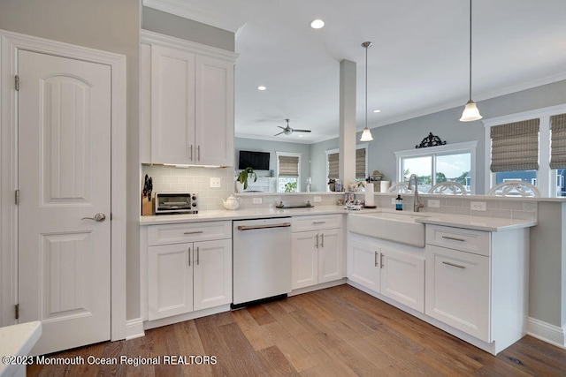 kitchen featuring pendant lighting, white dishwasher, sink, and white cabinets