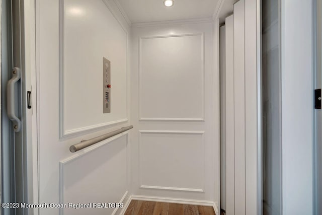 interior details featuring crown molding, elevator, and wood-type flooring