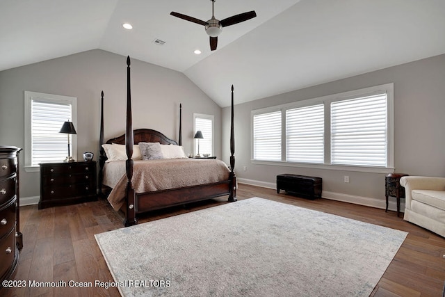 bedroom with dark wood-type flooring, ceiling fan, vaulted ceiling, and multiple windows