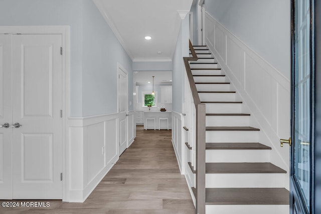 staircase with ornamental molding and hardwood / wood-style flooring