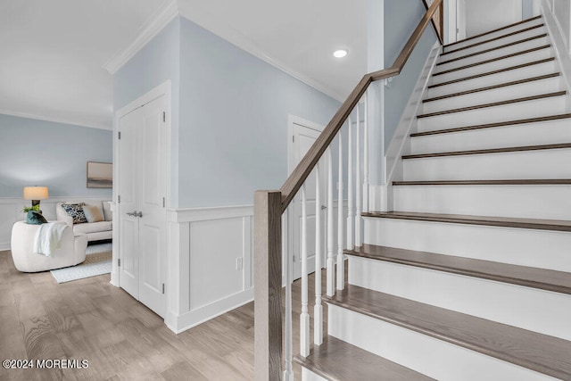 staircase featuring hardwood / wood-style floors and crown molding