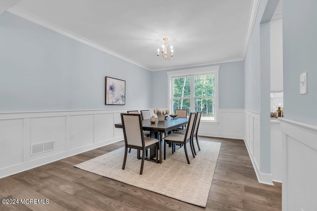 dining area with crown molding, dark hardwood / wood-style floors, and a chandelier