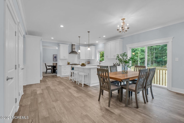 dining room with crown molding, light hardwood / wood-style flooring, and a chandelier