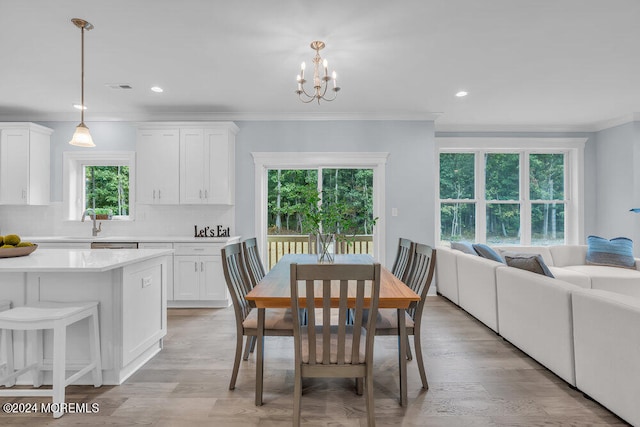 dining space featuring crown molding, light hardwood / wood-style flooring, and plenty of natural light