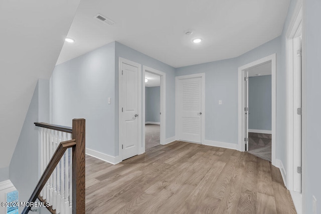 hallway with light hardwood / wood-style floors