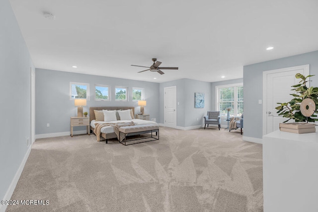 carpeted bedroom featuring multiple windows and ceiling fan