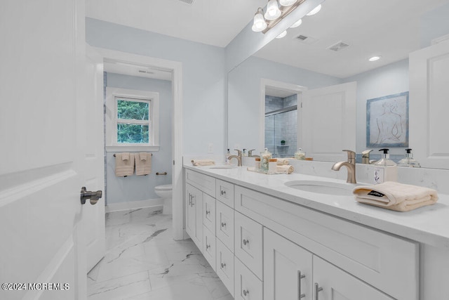 bathroom with vanity, a shower with shower door, and toilet