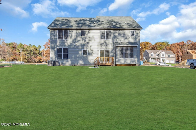 back of house with a wooden deck and a lawn