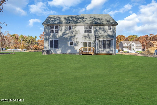 rear view of house with a yard, cooling unit, and a wooden deck