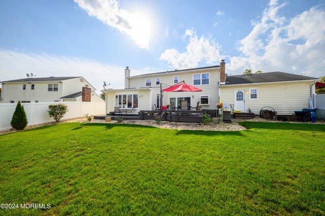 back of property featuring a yard and a deck