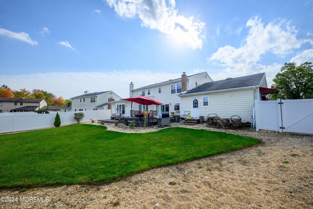 back of house featuring a patio and a lawn