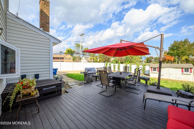 wooden terrace featuring a storage shed and grilling area