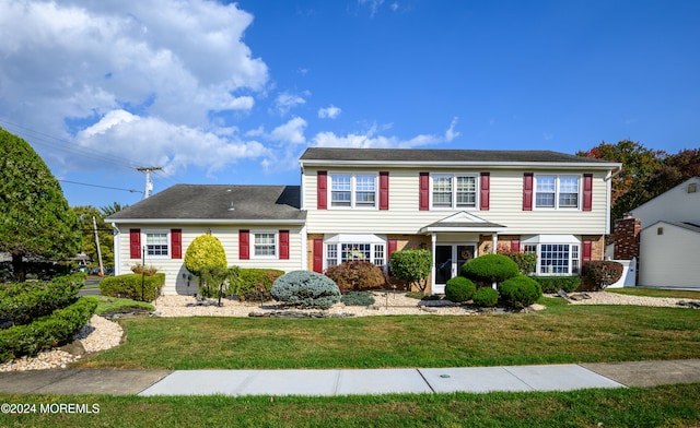 colonial inspired home featuring a front yard