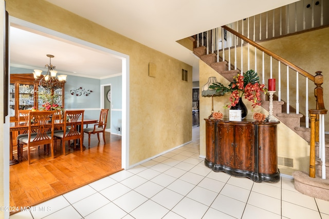 interior space with ornamental molding, light hardwood / wood-style flooring, and a notable chandelier