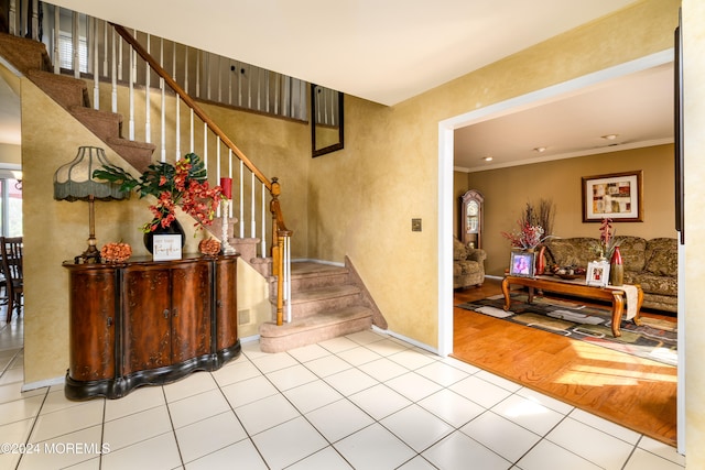 foyer with ornamental molding and light hardwood / wood-style floors