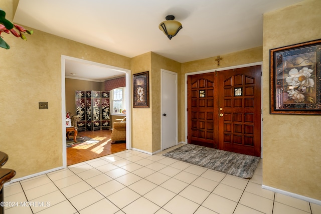 foyer entrance featuring ornamental molding and light wood-type flooring