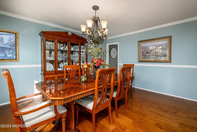 dining room with a notable chandelier, ornamental molding, and dark hardwood / wood-style floors