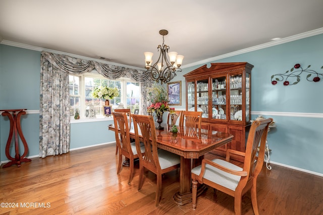 dining space with a notable chandelier, hardwood / wood-style floors, and crown molding