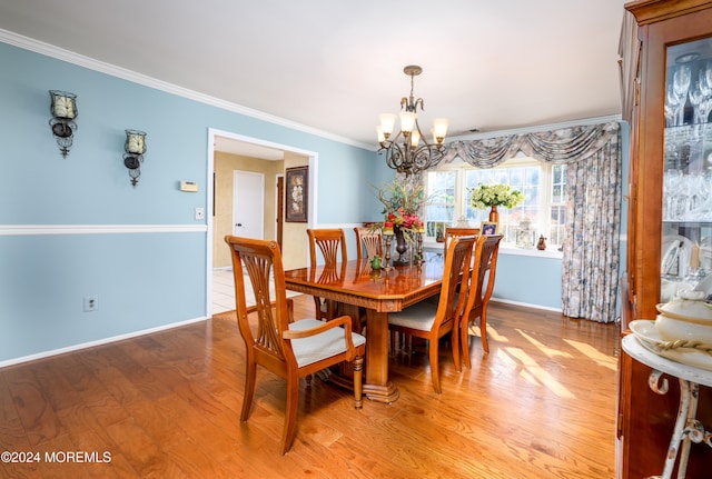 dining room with a notable chandelier, light hardwood / wood-style floors, and crown molding