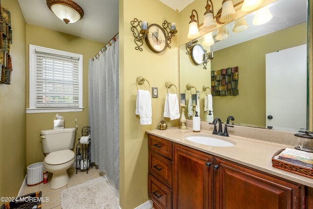 bathroom with toilet, vanity, and tile patterned floors