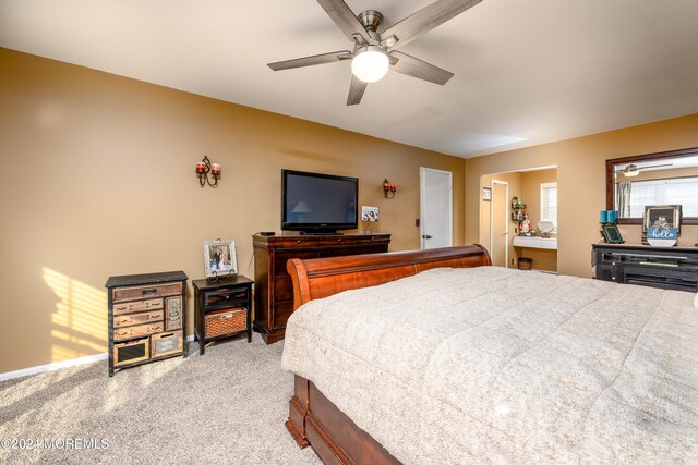 carpeted bedroom featuring ceiling fan and ensuite bathroom