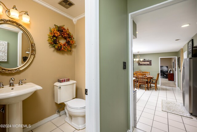 bathroom featuring tile patterned floors, crown molding, toilet, and sink