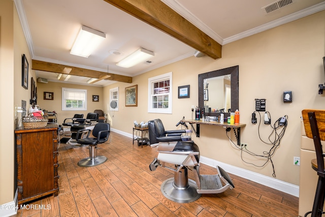 exercise room with ornamental molding and hardwood / wood-style flooring