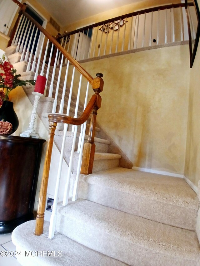 stairs with a notable chandelier