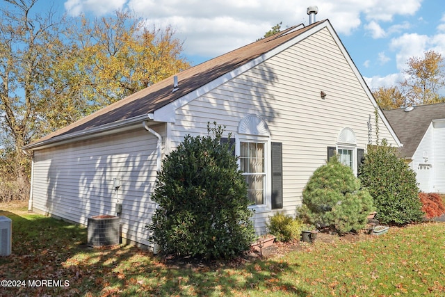 view of side of property with a yard and central AC unit