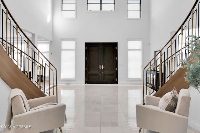 tiled entryway with a wealth of natural light and a high ceiling