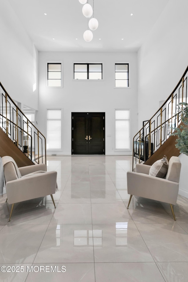 tiled entrance foyer featuring a towering ceiling and plenty of natural light